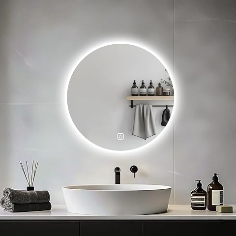Miroir rond Jamuboche rétroéclairé installé au-dessus d’un lavabo dans une salle de bain claire.
