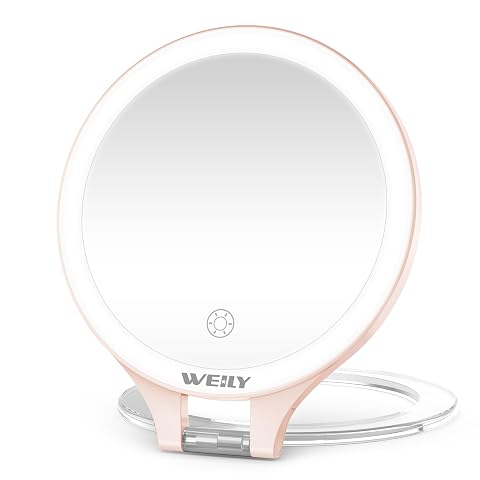 Miroir de maquillage rond rose à support pliable, posé sur une tablette dans une salle de bain claire