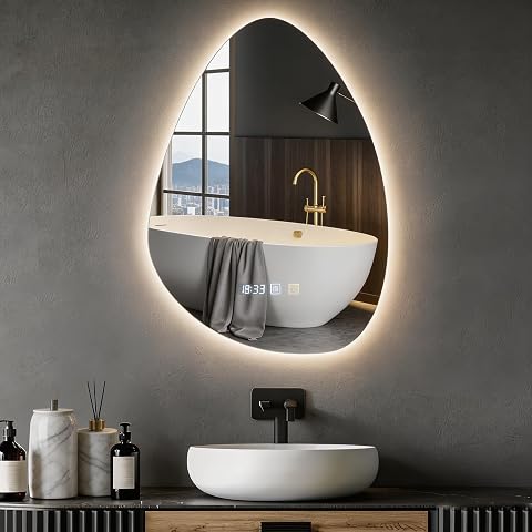 Miroir mural LED asymétrique sans cadre, éclairé dans une salle de bain contemporaine aux tons minéraux.